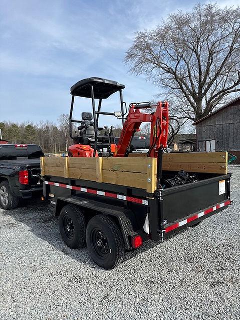 Mini excavator loaded on trailer heading to palm installation job
