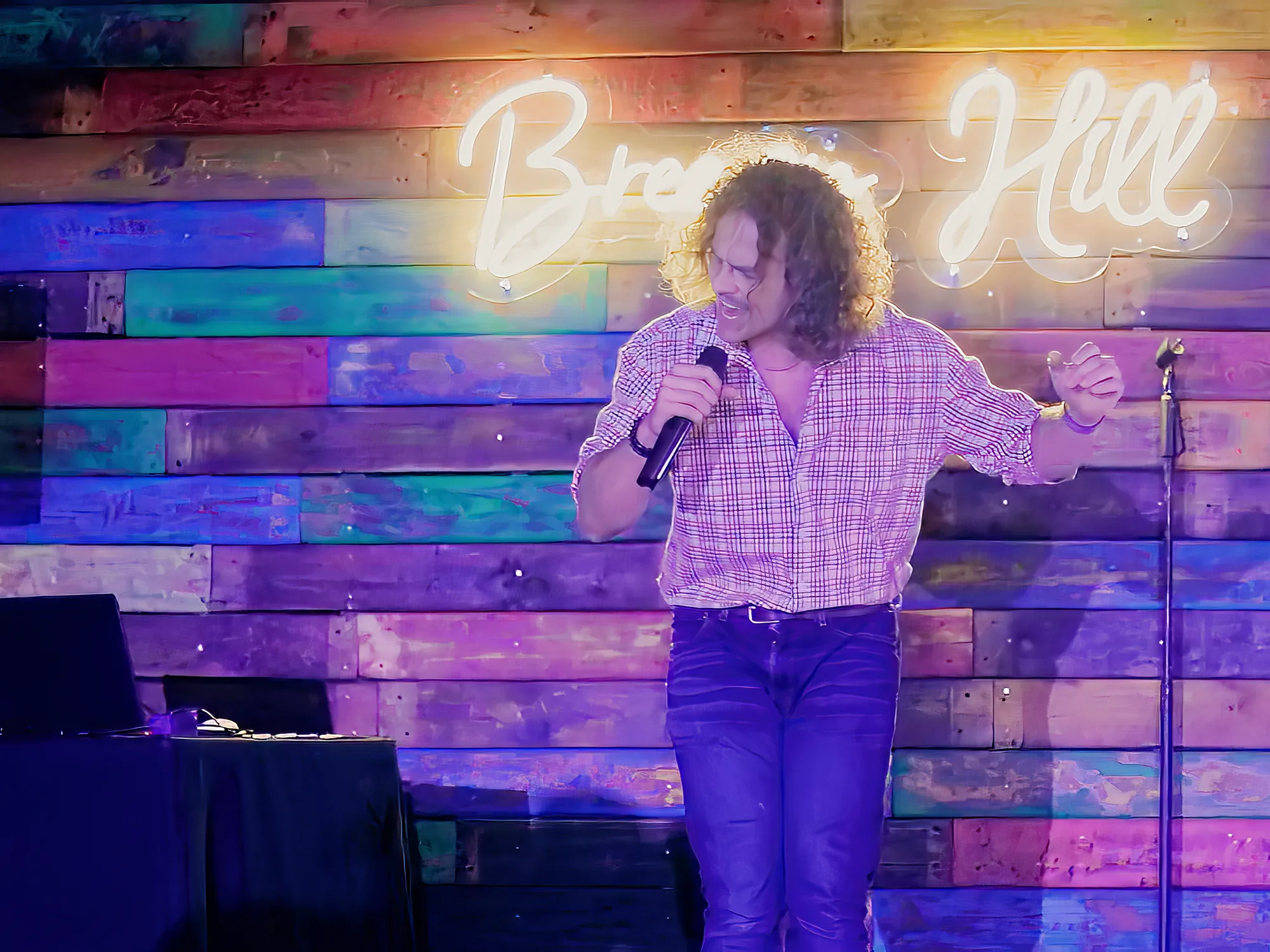 Singer on the mic on the small stage at Breezy's