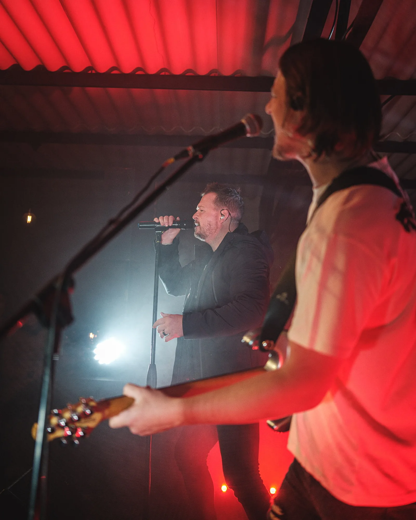 Live band playing on stage under red lights at Breezy's