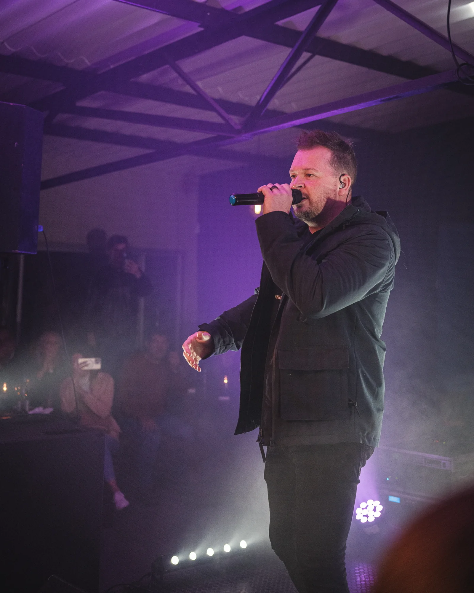 Singer performing under purple stage lights at Breezy's