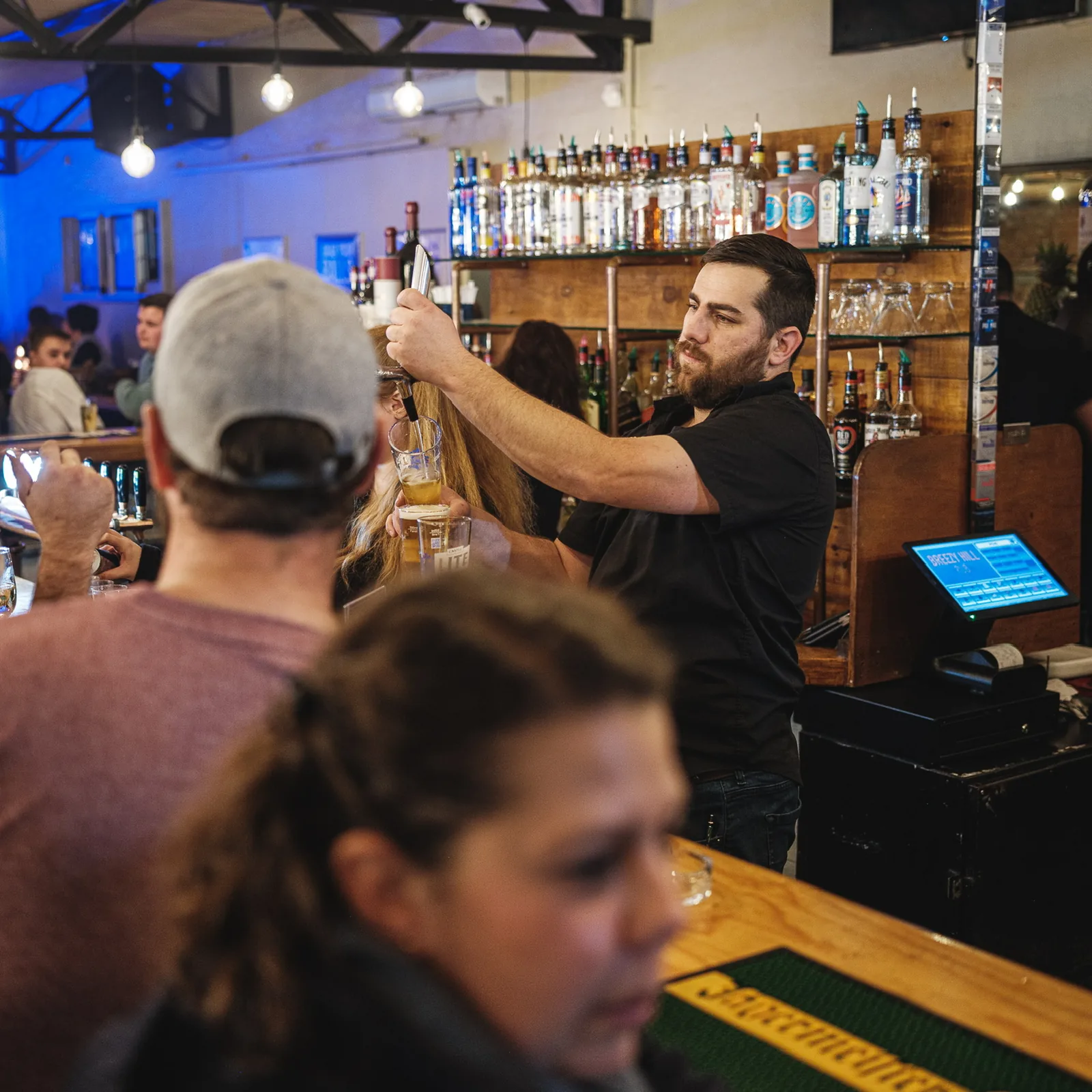 Bartender pouring a drink at the bar at Breezy's