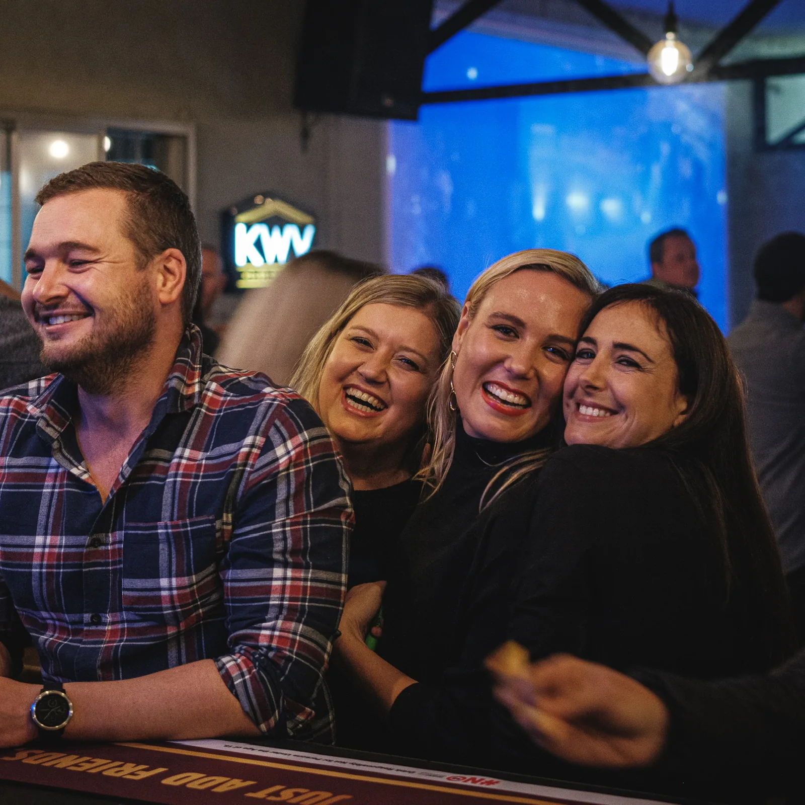 Group of friends laughing at the bar at Breezy's
