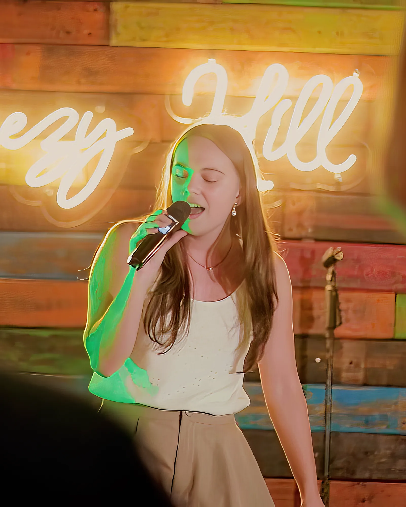Young woman singing on the mic at Breezy's