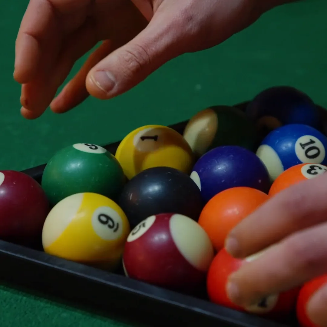 Racking the balls on a pool table at Breezy's