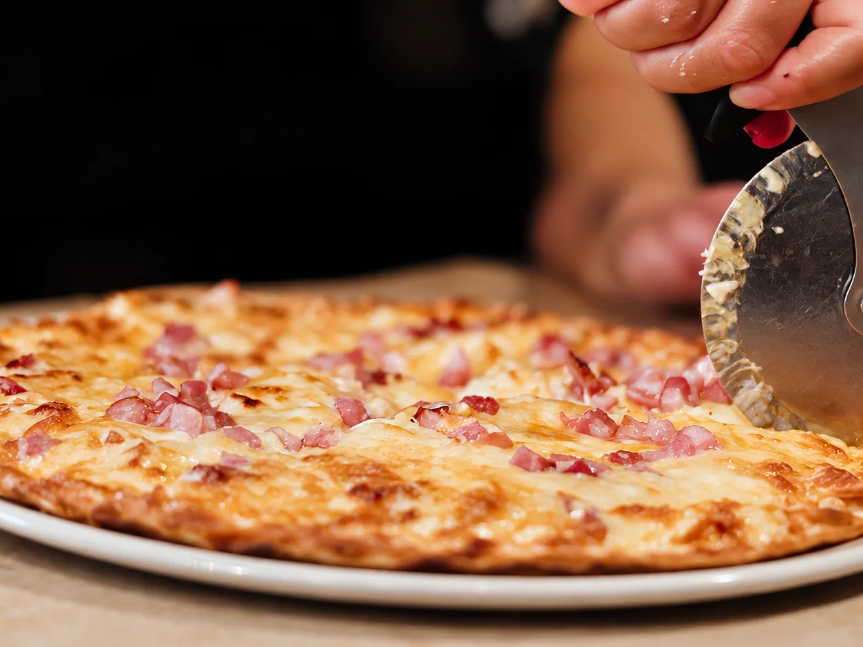 Pizza being sliced at Breezy's