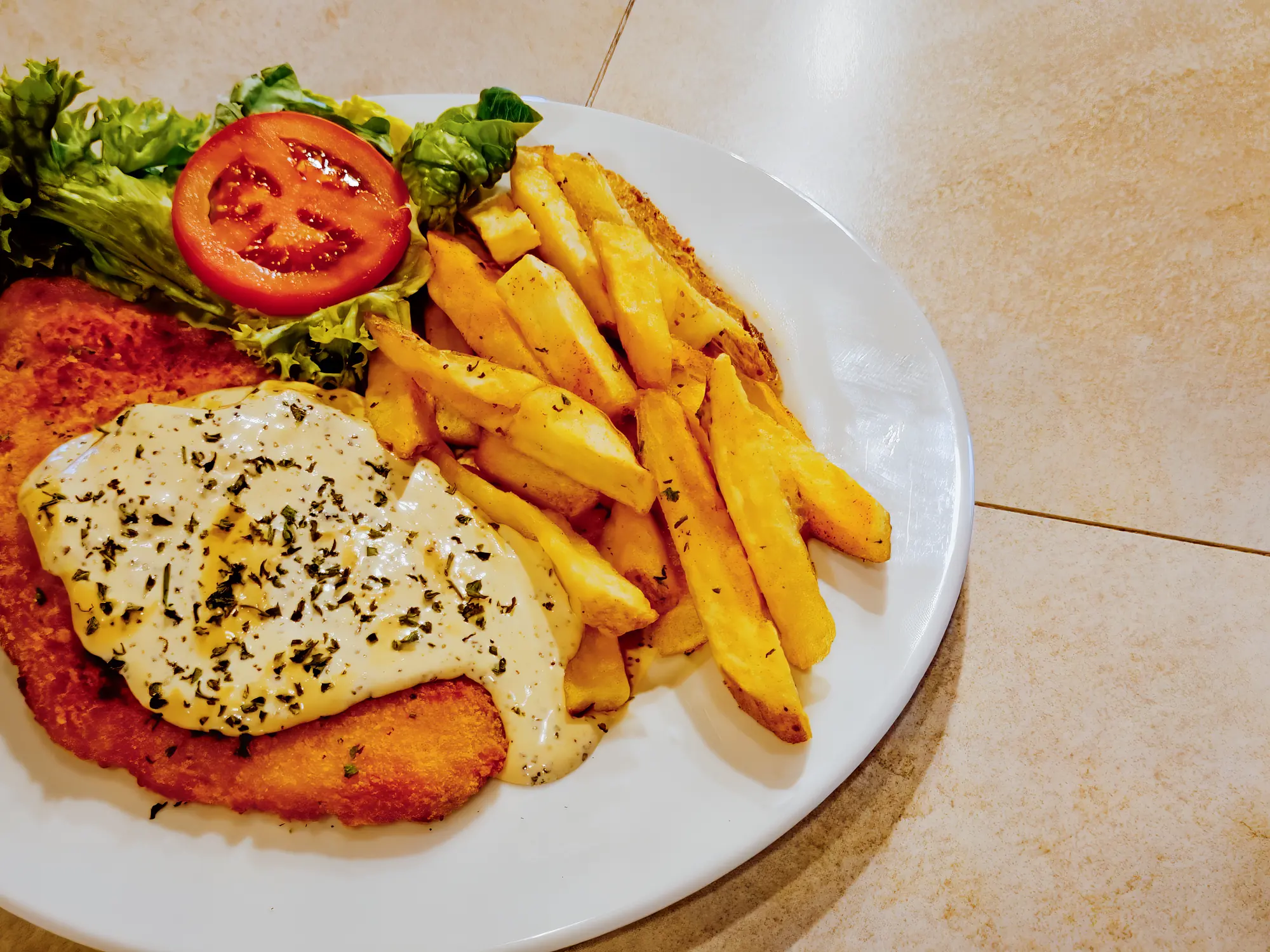 Chicken schnitzel with chips and salad at Breezy's