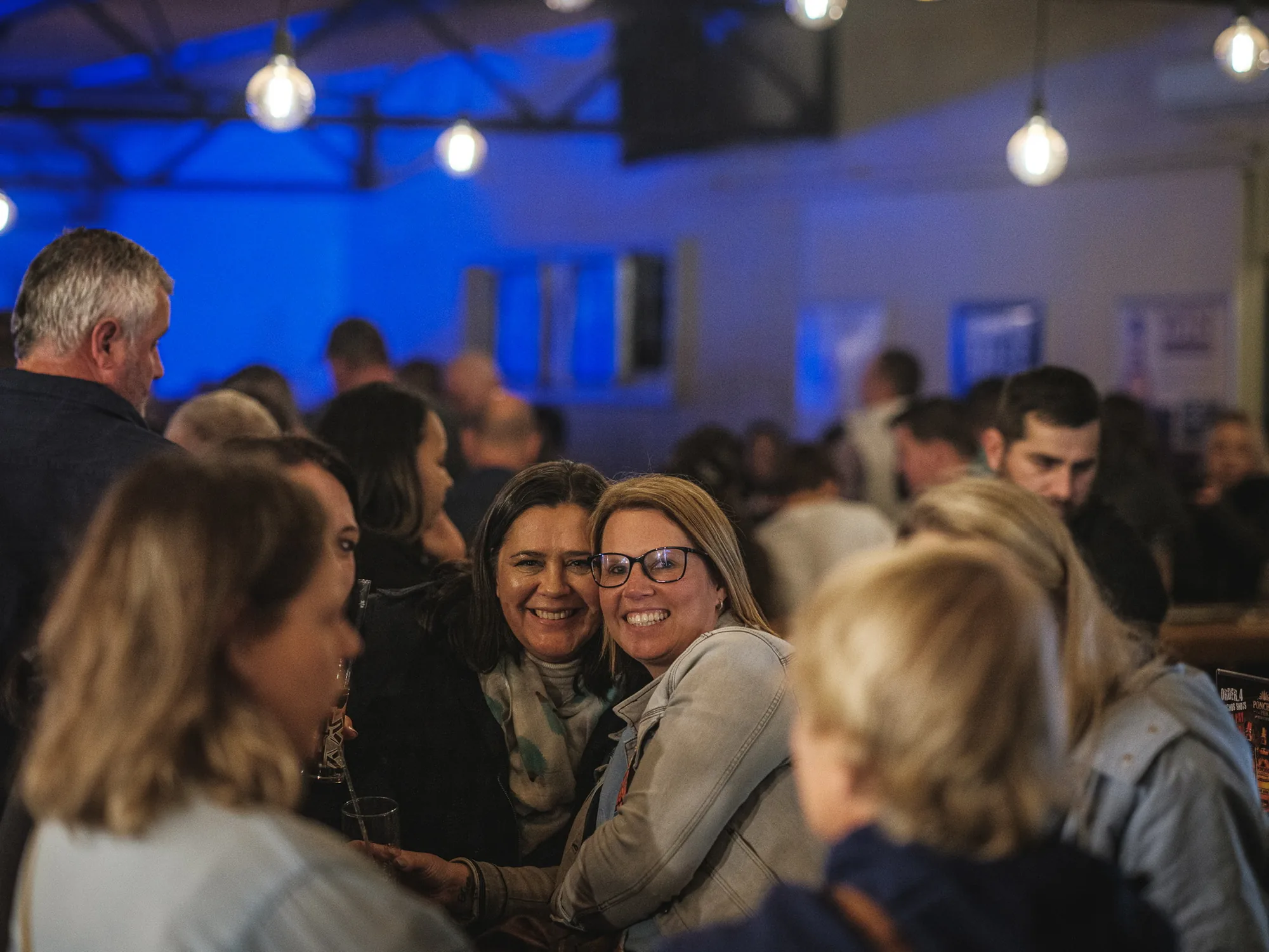 Guests smiling in the crowd at a live show at Breezy's