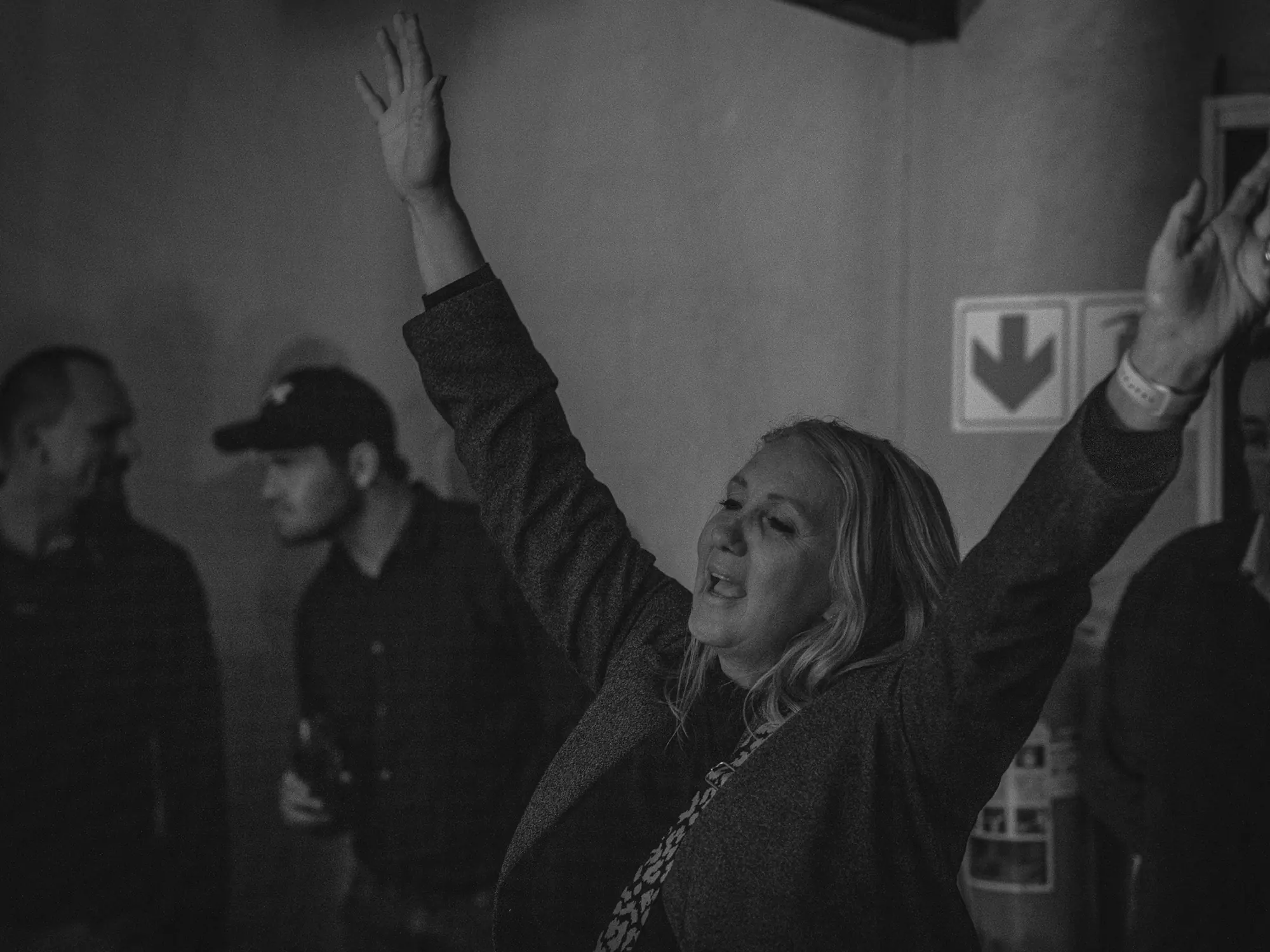 Guest with her arms up enjoying the music at Breezy's