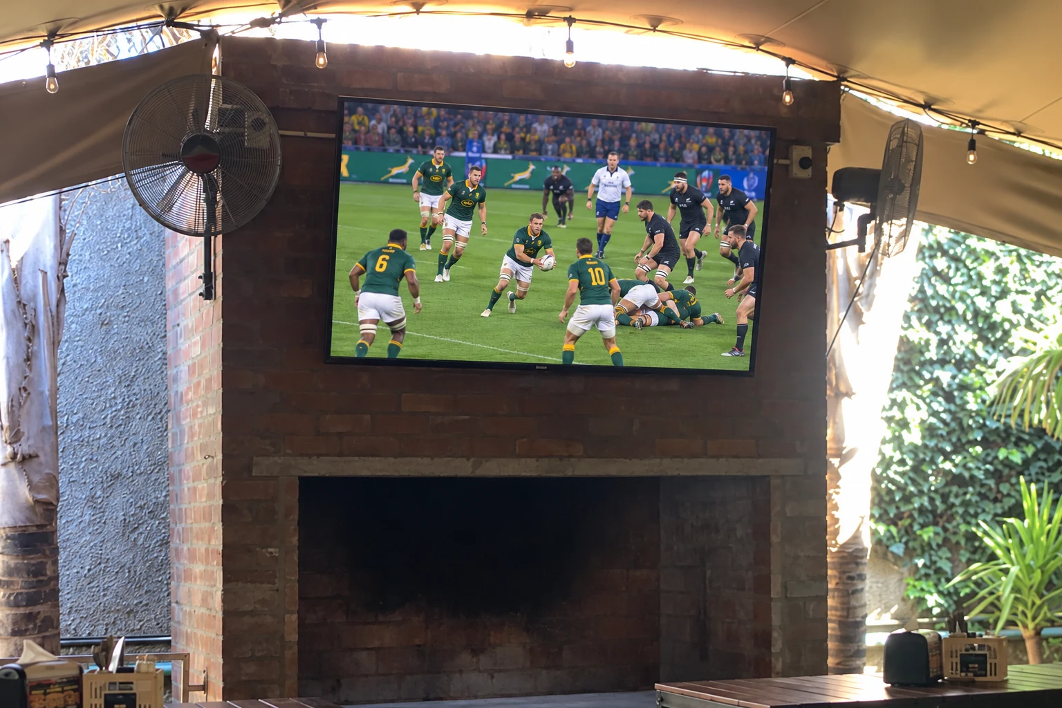 Rugby match on a large TV above the fireplace at Breezy's