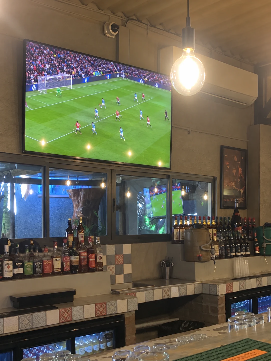 Football match on a TV above the bar at Breezy's