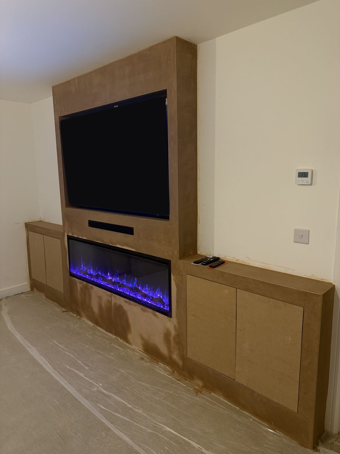 Media wall with built-in cupboards and a fire