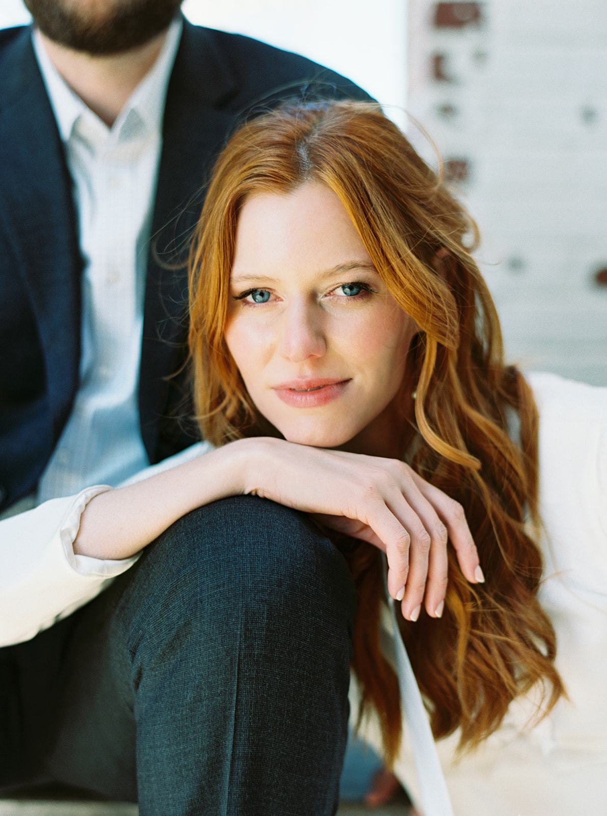 Medium format film portrait of a bride resting a hand on her partner’s knee, soft natural light