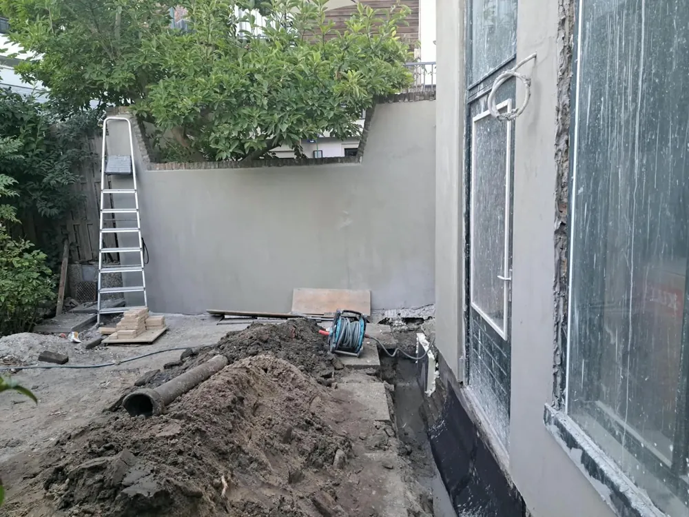 Gerepareerde tuinmuur met nieuwe stuclaag in de regio Rotterdam