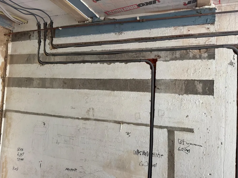 Nieuwe water en afvoerleidingen in sleuven voor een wasruimte in de regio Rotterdam