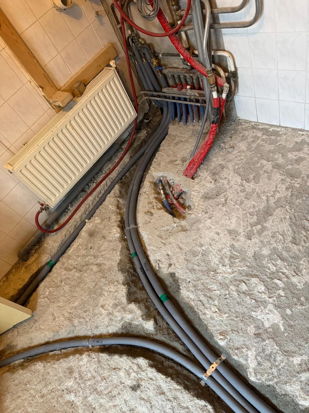 Nieuwe waterleidingen vanaf de verdeler door de vloer in de regio Rotterdam