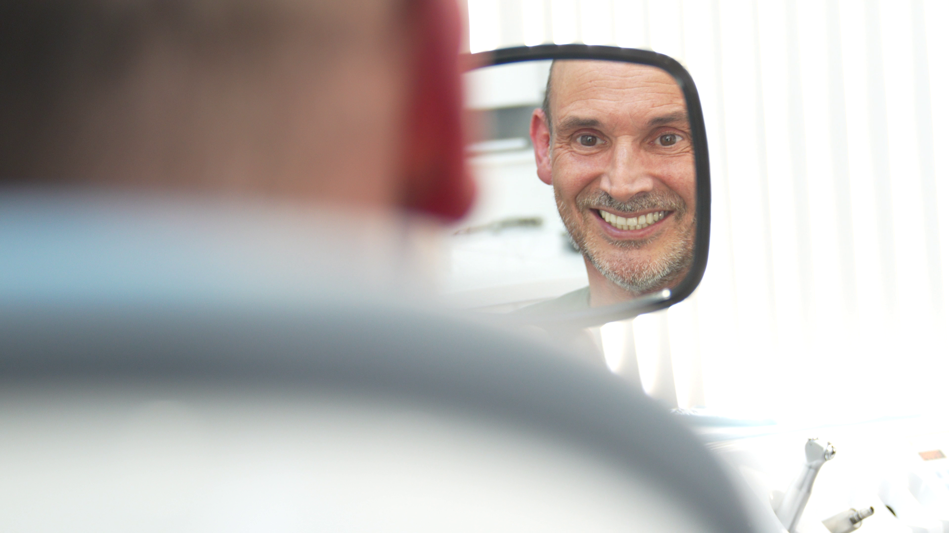 Patient smiling confidently after full arch dental implant treatment