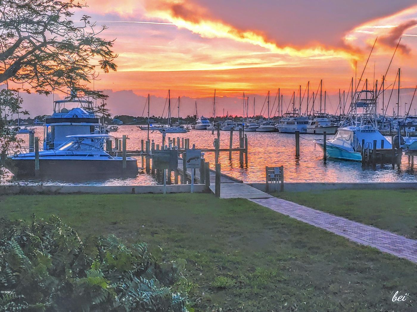 Sport-fishing boats docked in a Florida marina under an orange sunrise sky