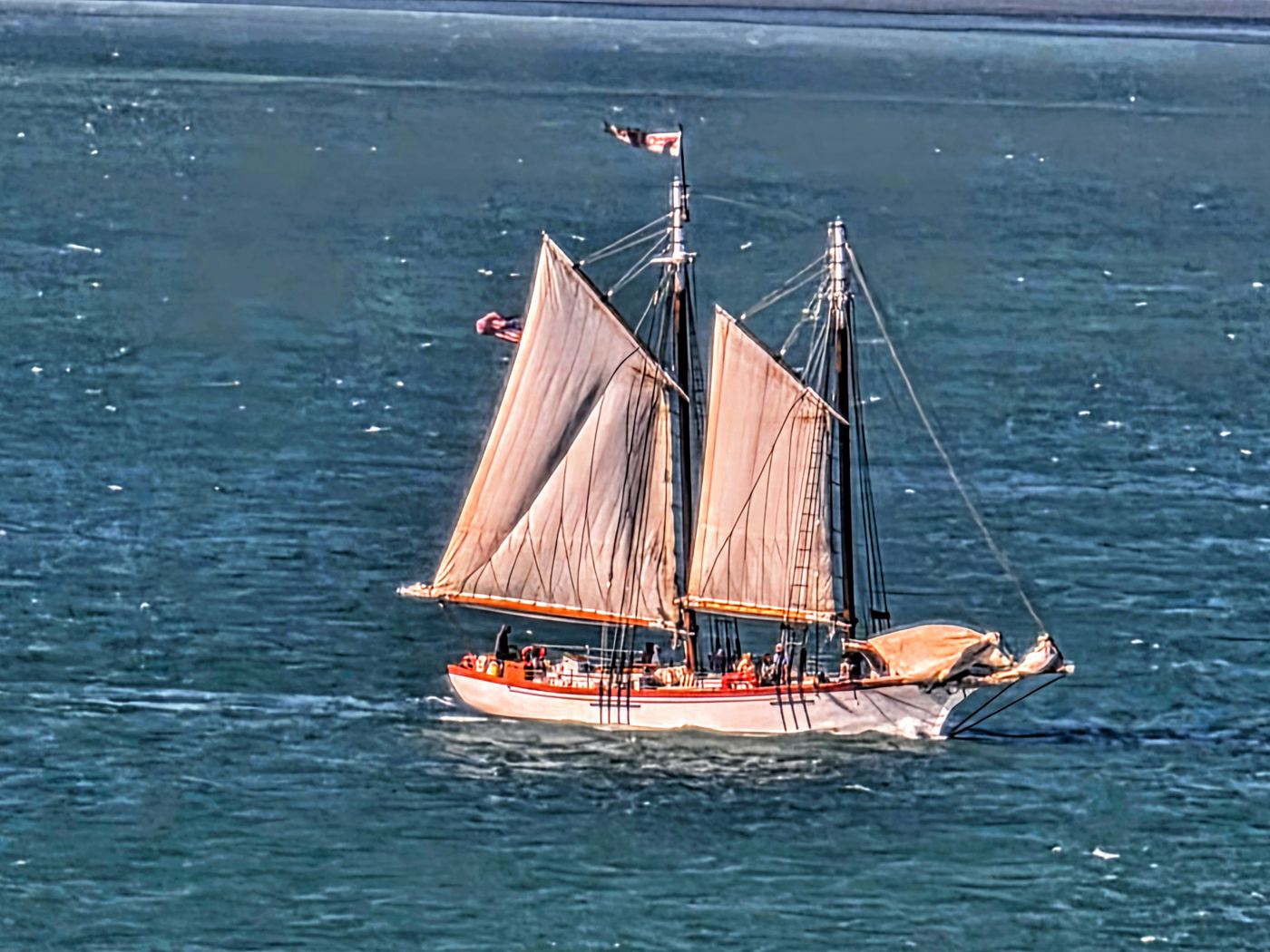 Two-masted schooner under full sail on blue-green Atlantic water