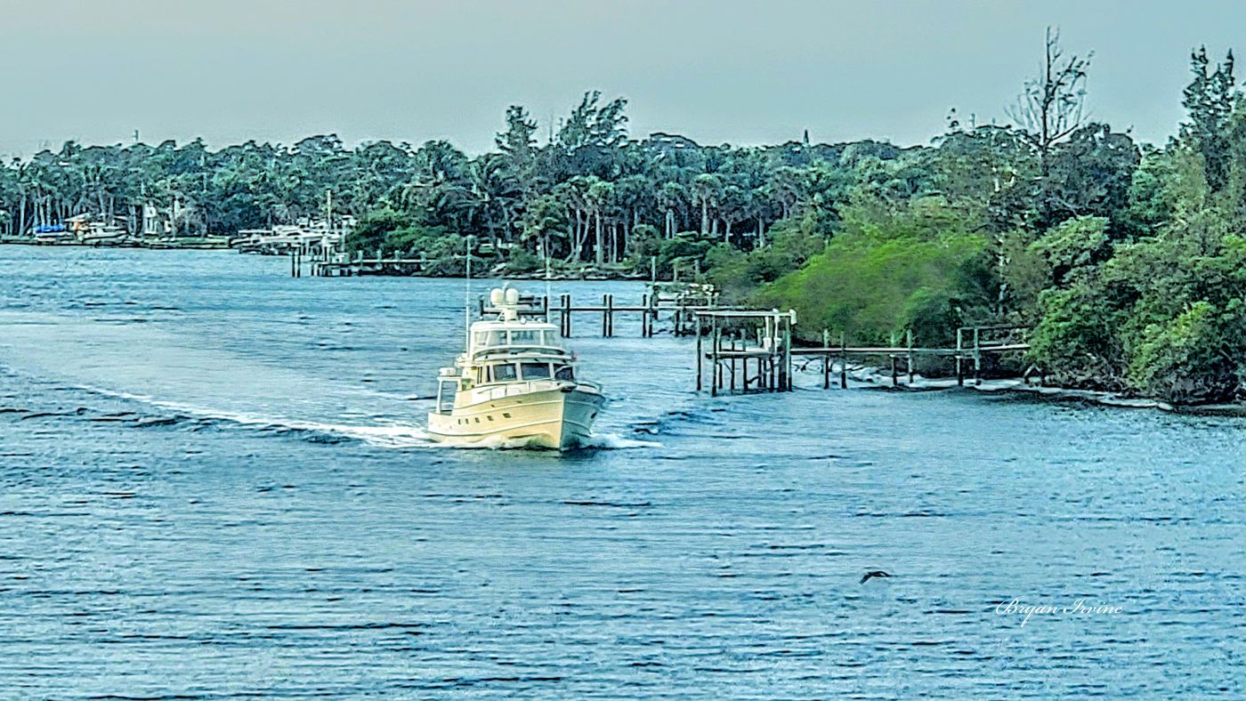Sport-fishing boat cruising a tree-lined Florida waterway