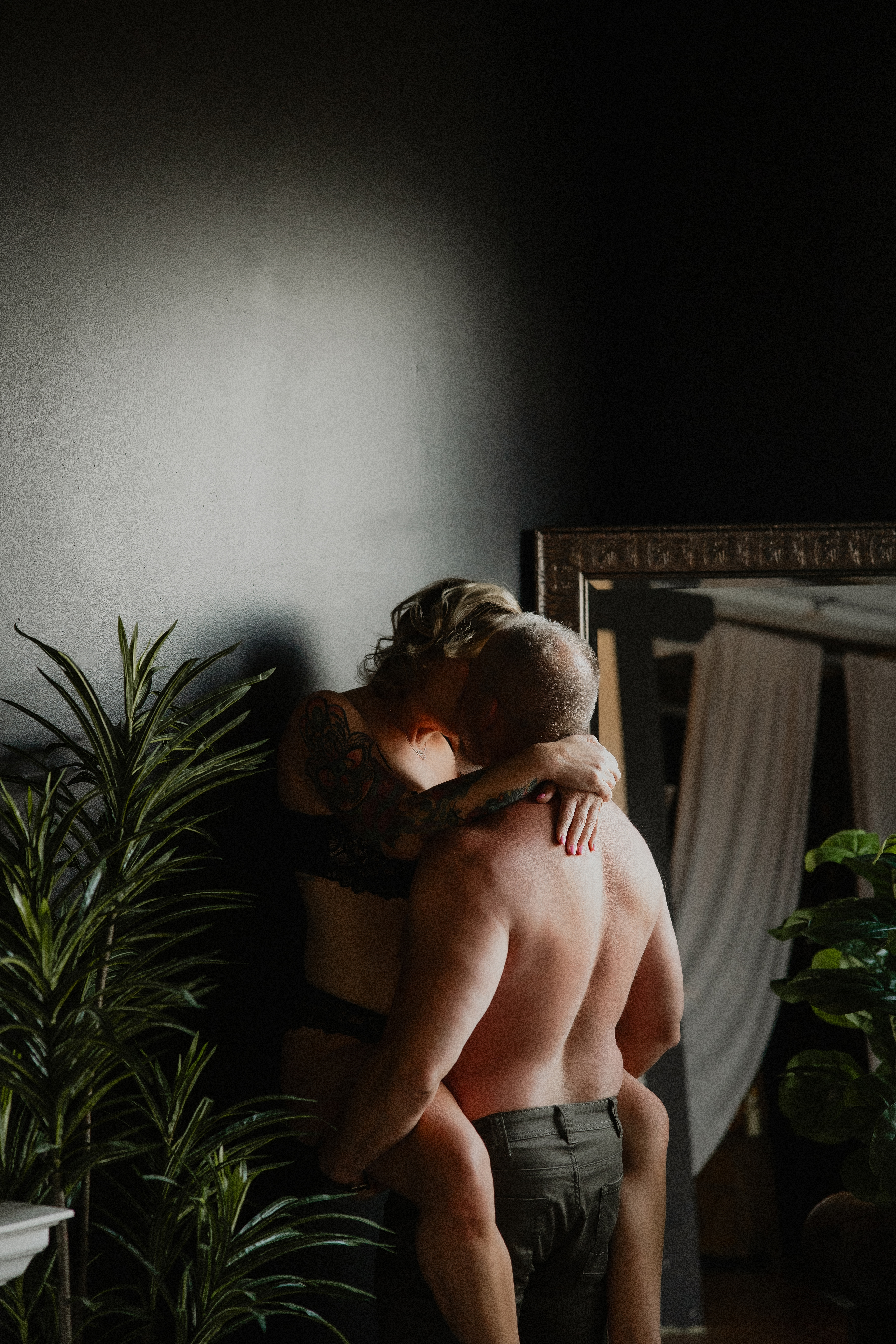 couple hugging in low light bedroom, cinematic intimate boudoir photography