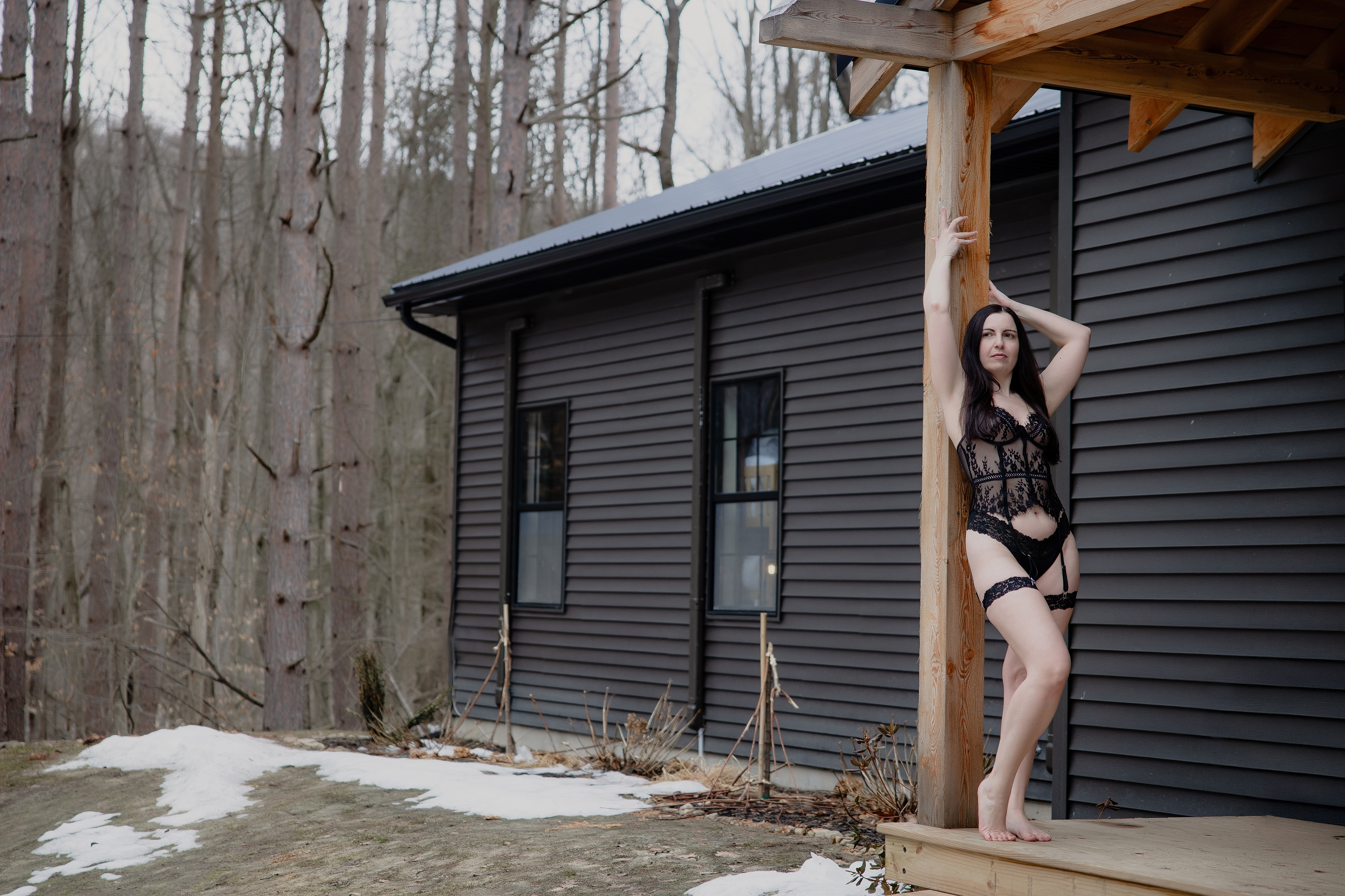 Woman standing outside a cabin in a wooded area during a retreat session.