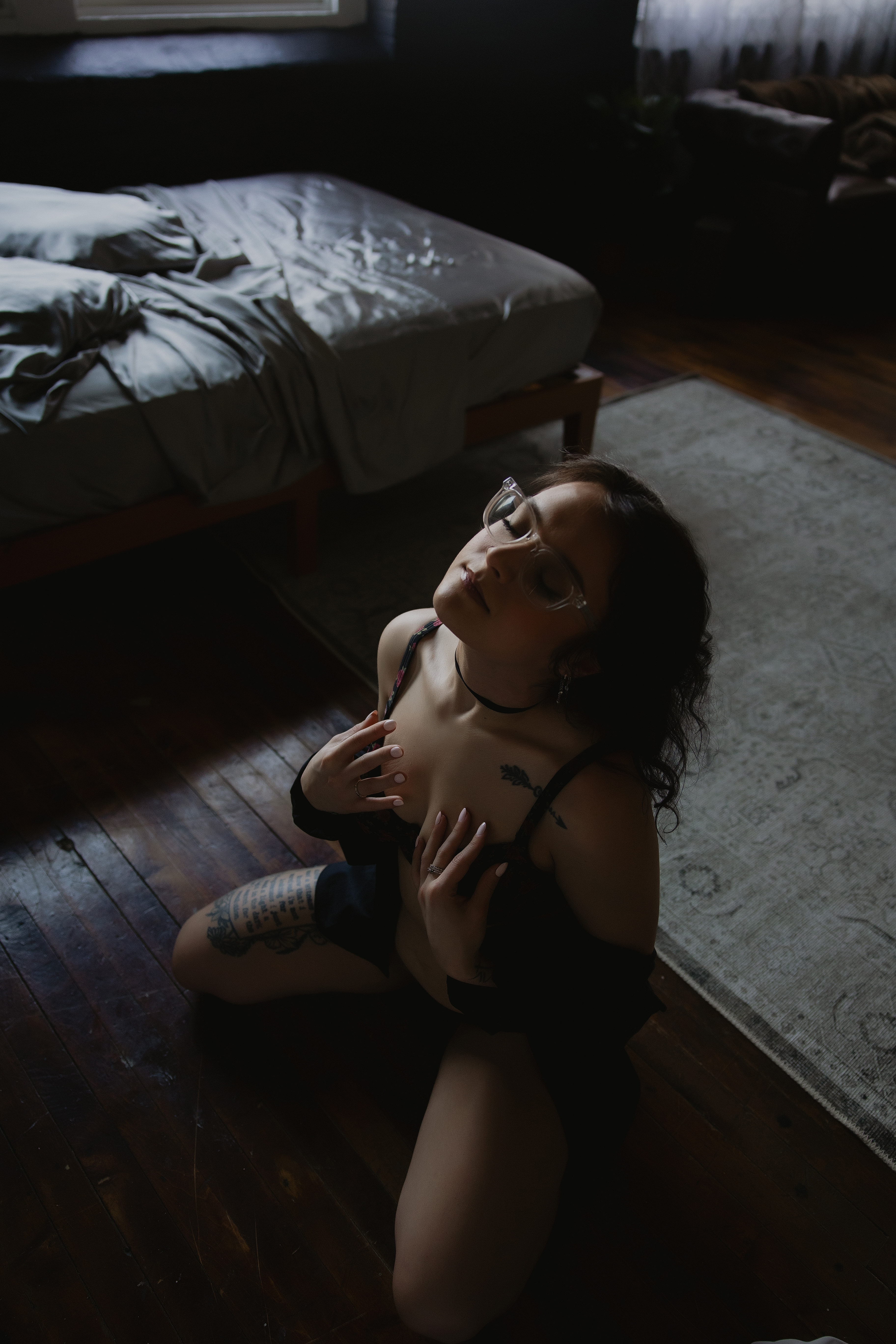 woman sitting on floor in lingerie, soft window light boudoir portrait