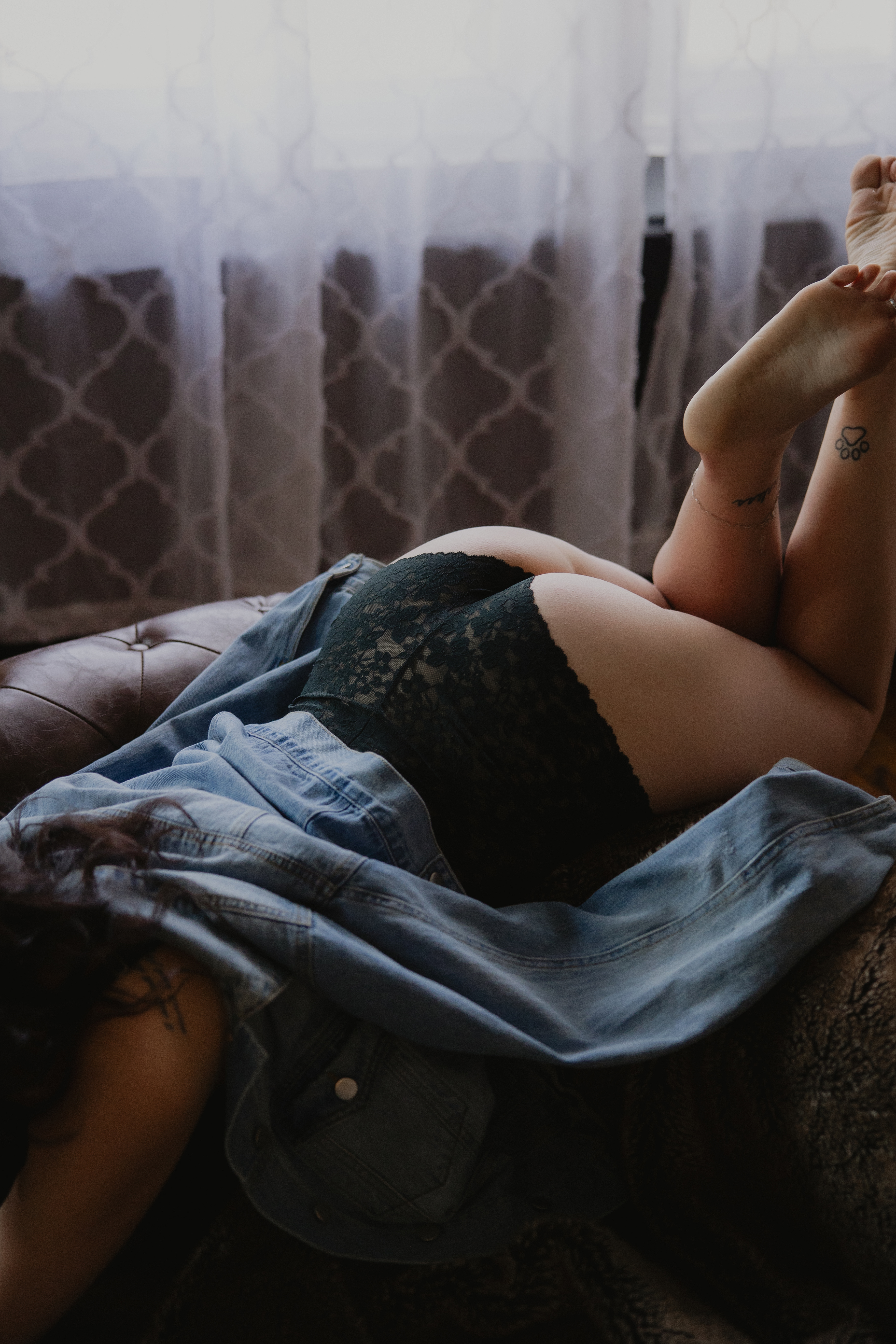 close-up of woman’s body in lingerie on bed, soft natural light boudoir detail