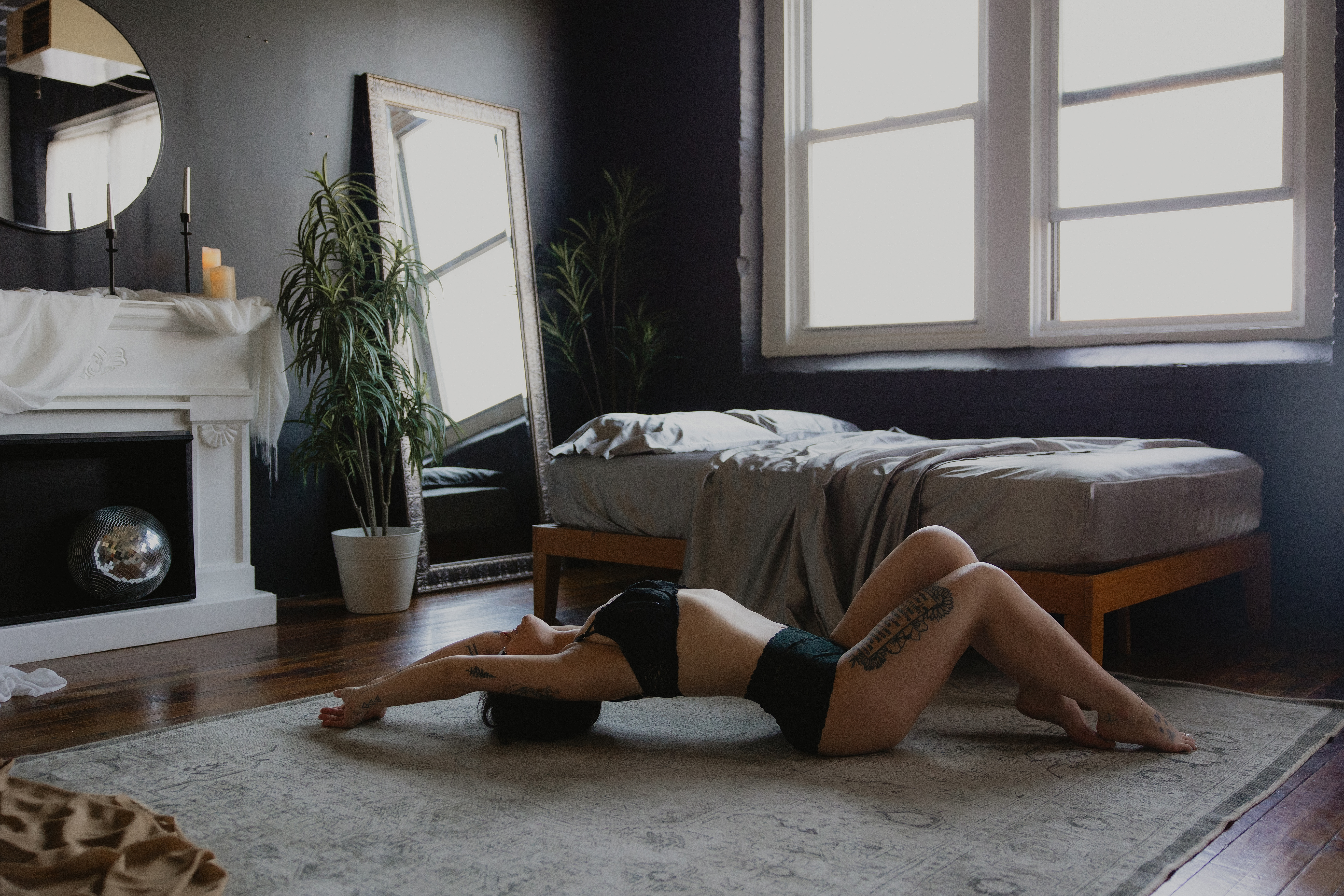 woman lying near window in lingerie, natural light boudoir photography session