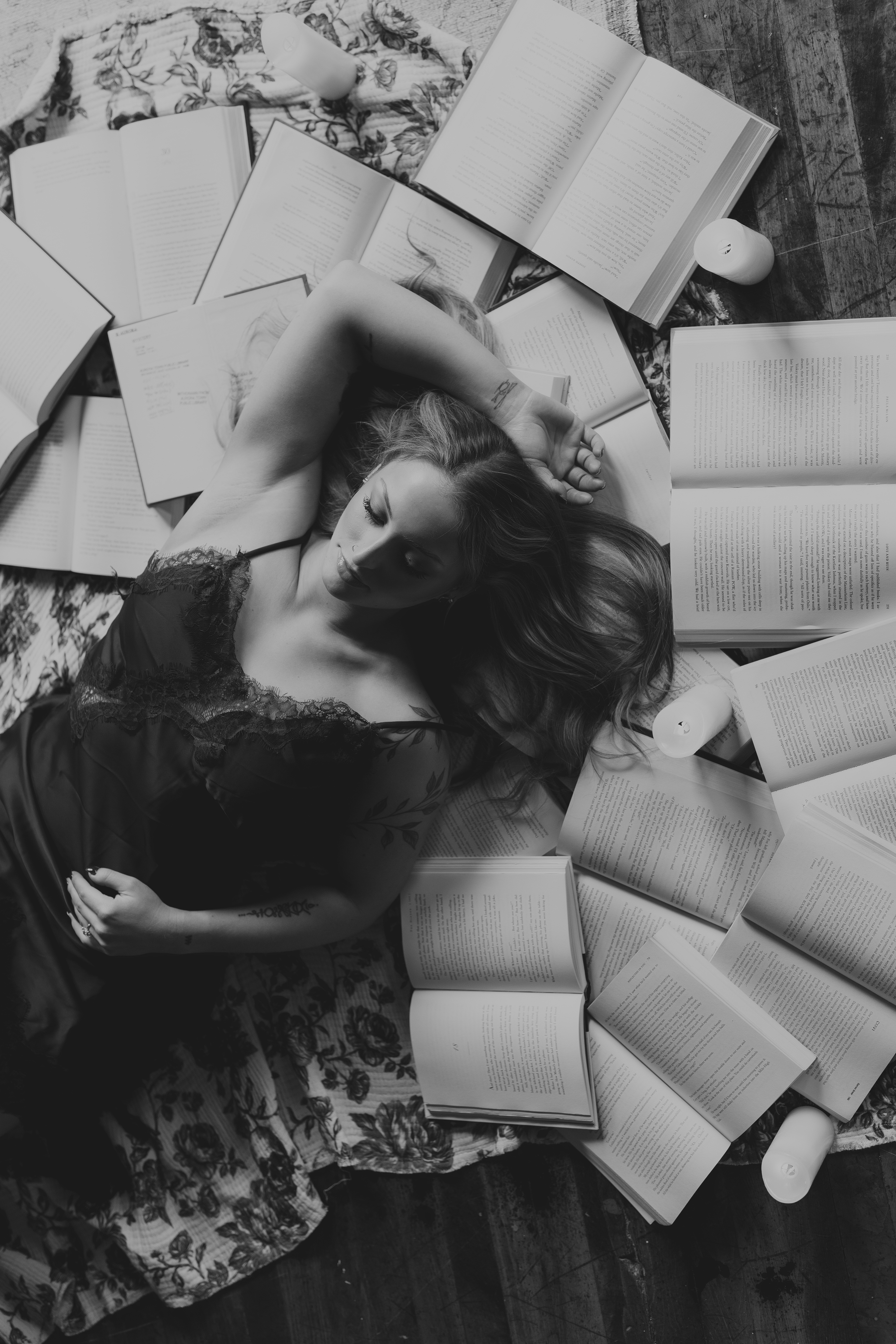 black and white photos of a woman laying in books open on the floor