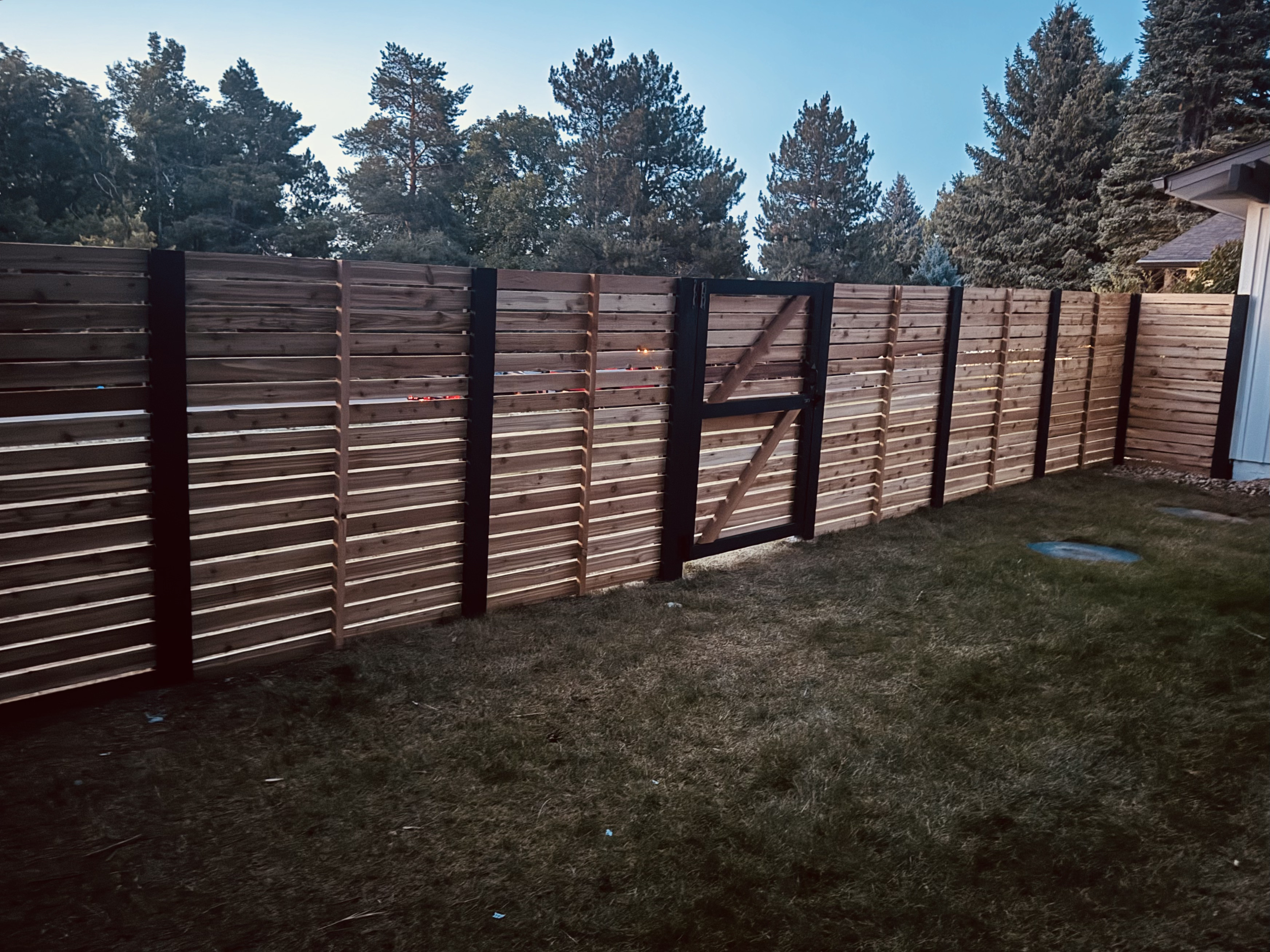 Close-up detail of a finished iron and wood fence installed by All About Fencing in Thornton, CO