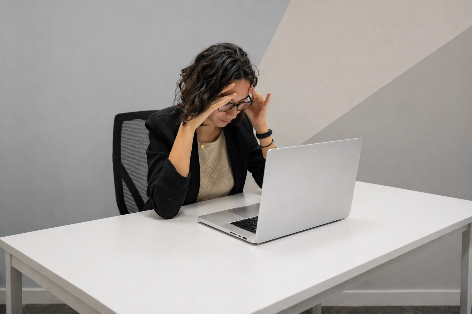 Business owner with her head down, overwhelmed at her laptop