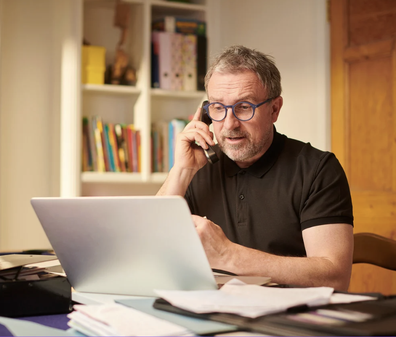 man looking at laptop while talking on the phone man looking at laptop while talking on the phone