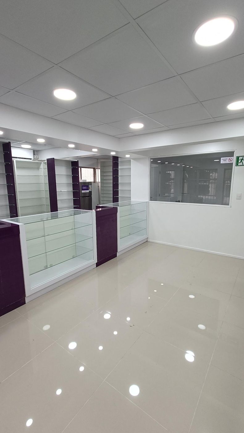 Interior del local Red Farma con vitrinas de vidrio, muebles morados y cielo modular con iluminación LED