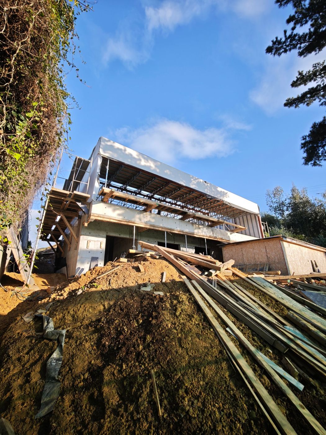 Casa en construcción en Lomas San Sebastián, con muros de hormigón en ladera y segundo piso en estructura metálica