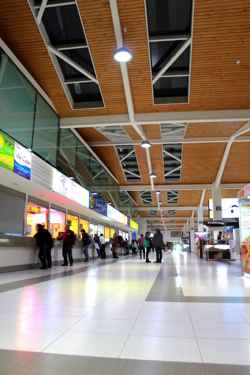Hall interior del Terminal de Buses Collao, con boleterías, cielo de madera y lucarnas con estructura metálica