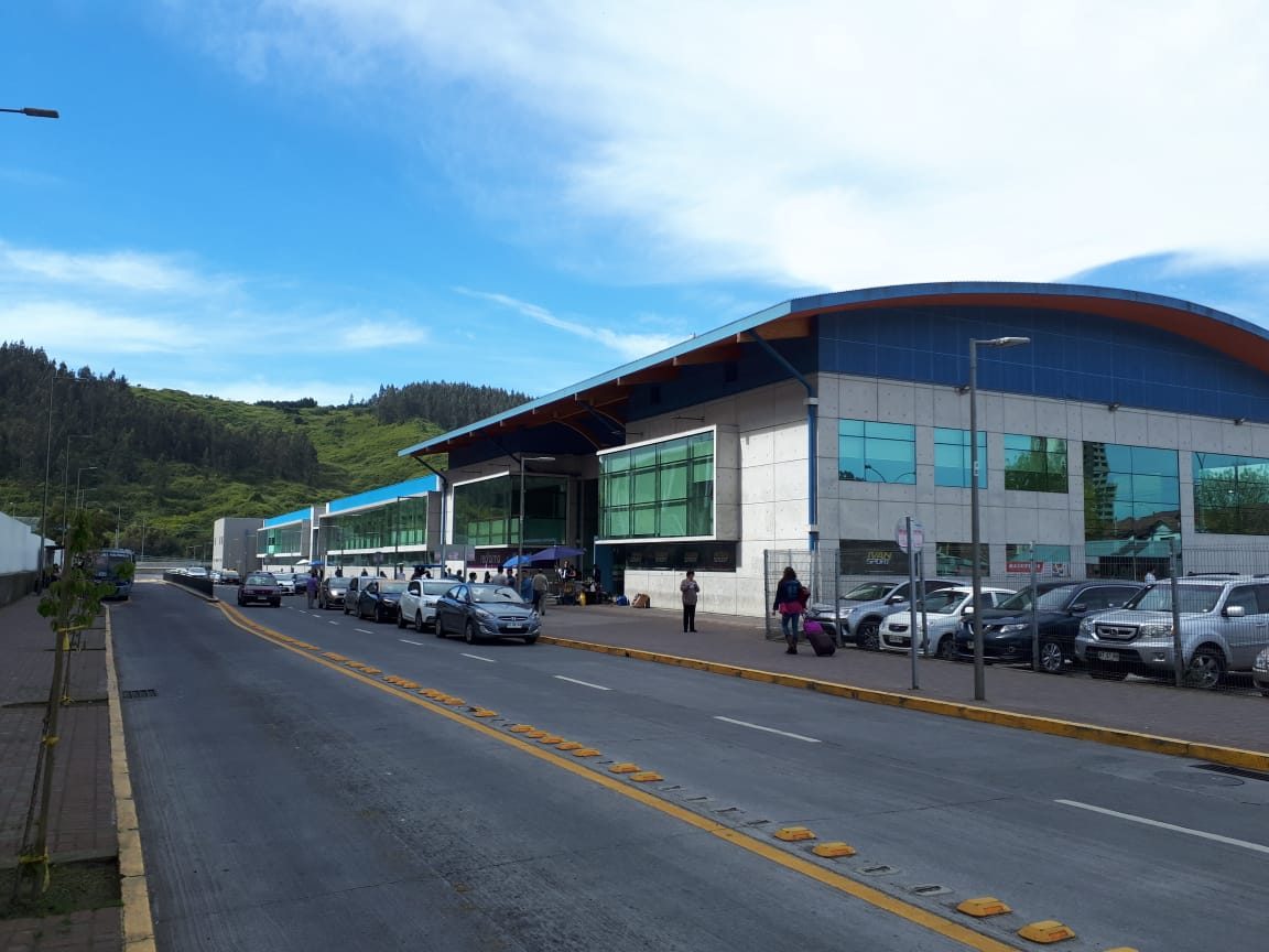 Fachada del Terminal de Buses Collao en Concepción, con techo curvo y ventanales verdes