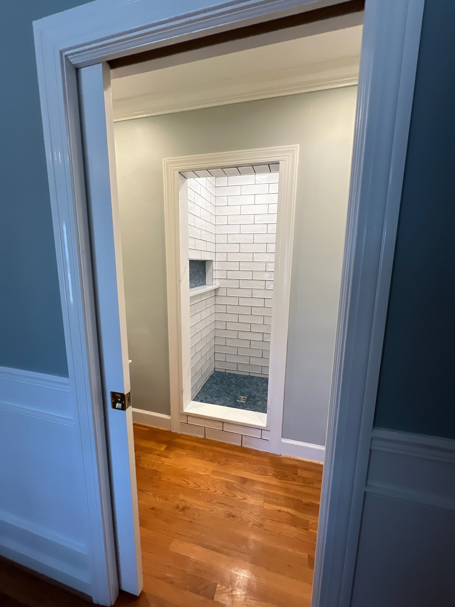 a bathroom with a shower and wood floor