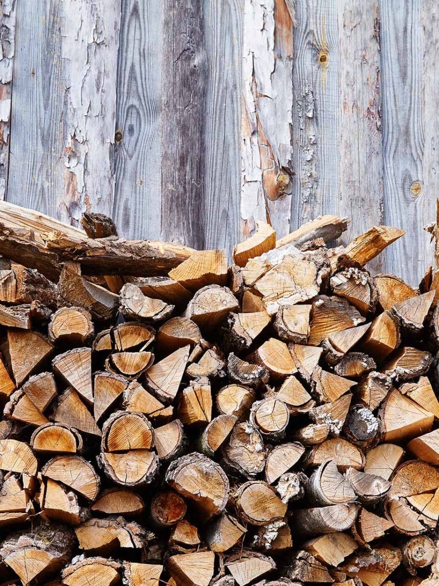 a pile of wood next to a wood wall