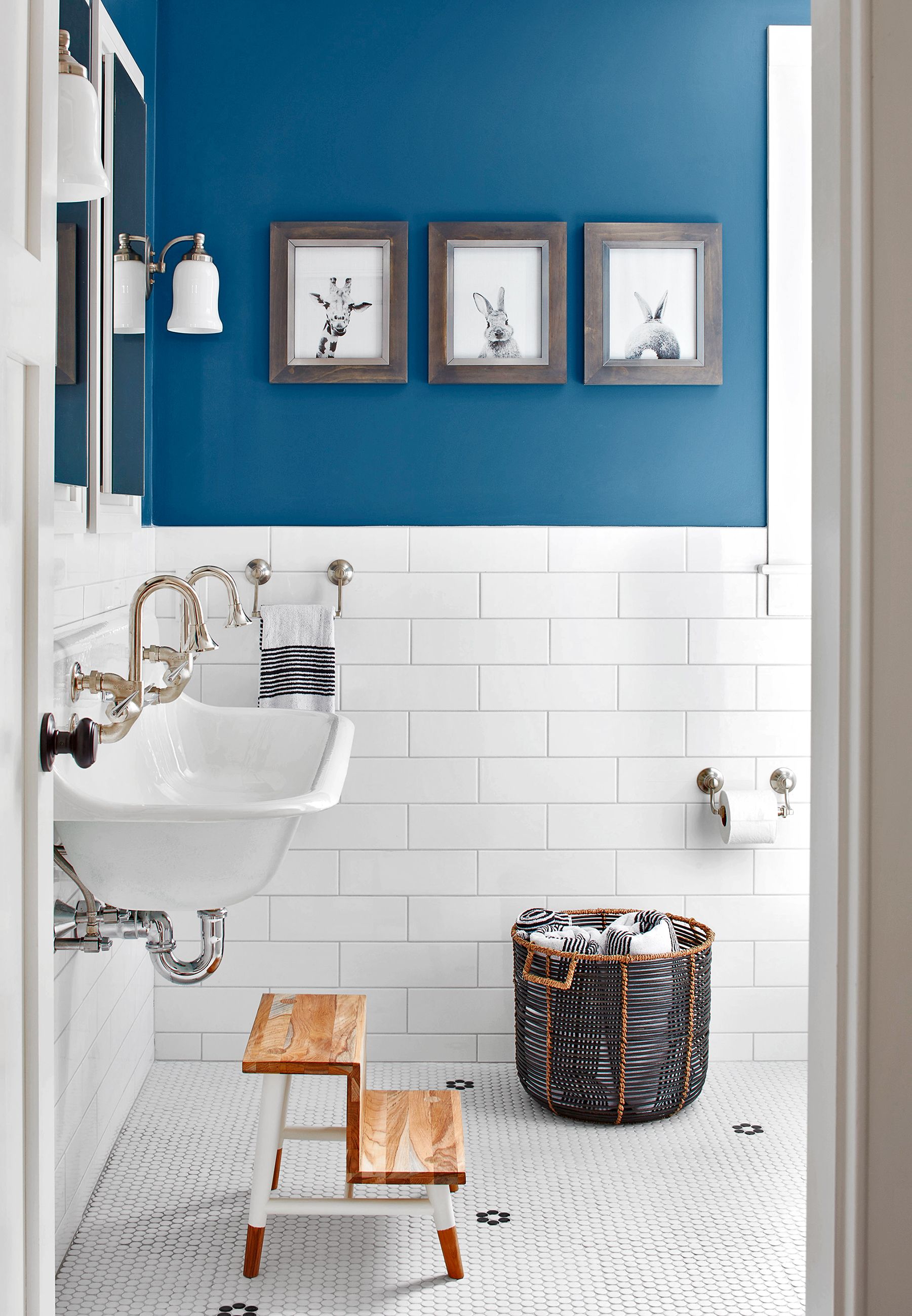 a bathroom with a basket and pictures on the wall