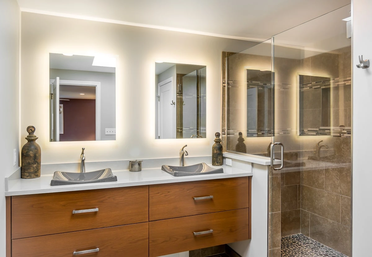 a bathroom with a glass shower and double sink