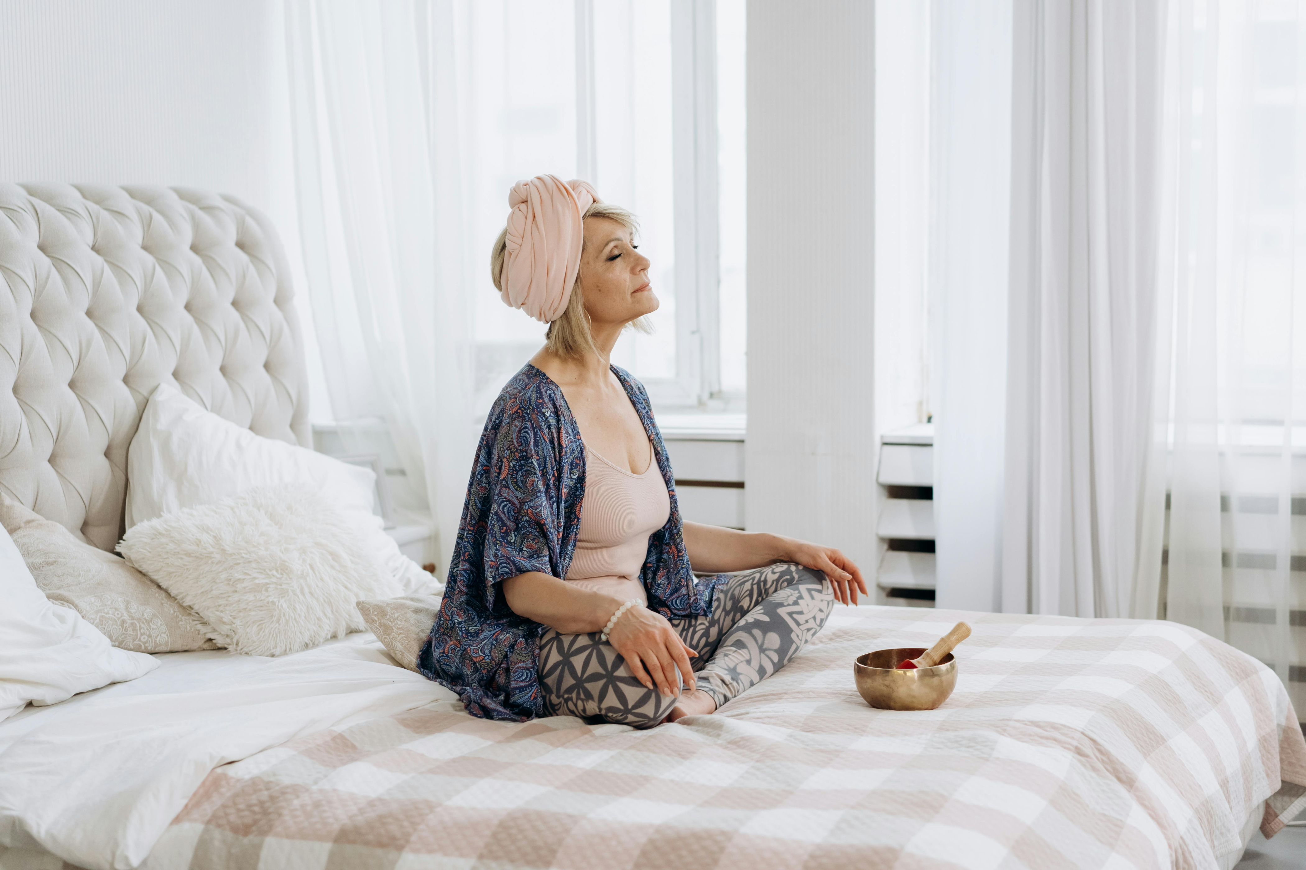 A woman in a calm, softly lit space, representing the somatic and body-level healing work that recalibrates the nervous system for sustainable business growth.
