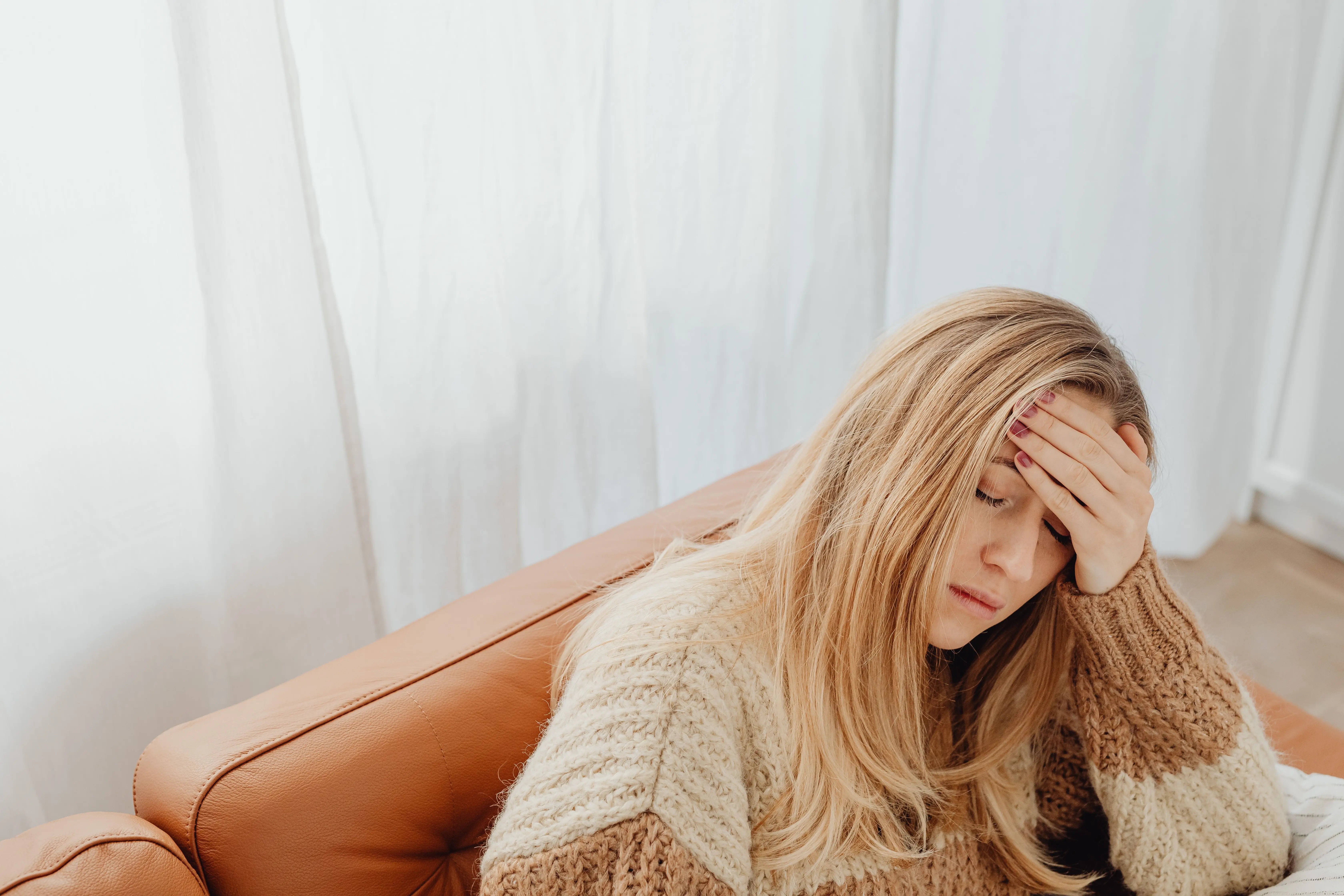 Female entrepreneur sitting quietly representing the emotional weight of identity shifts in business growth Female entrepreneur sitting quietly representing the emotional weight of identity shifts in business growth