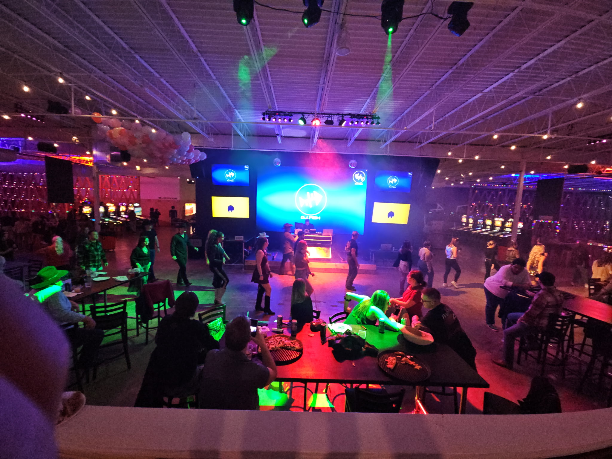 An Essential AV evening event — casino-style gaming tables under full-color stage lighting.