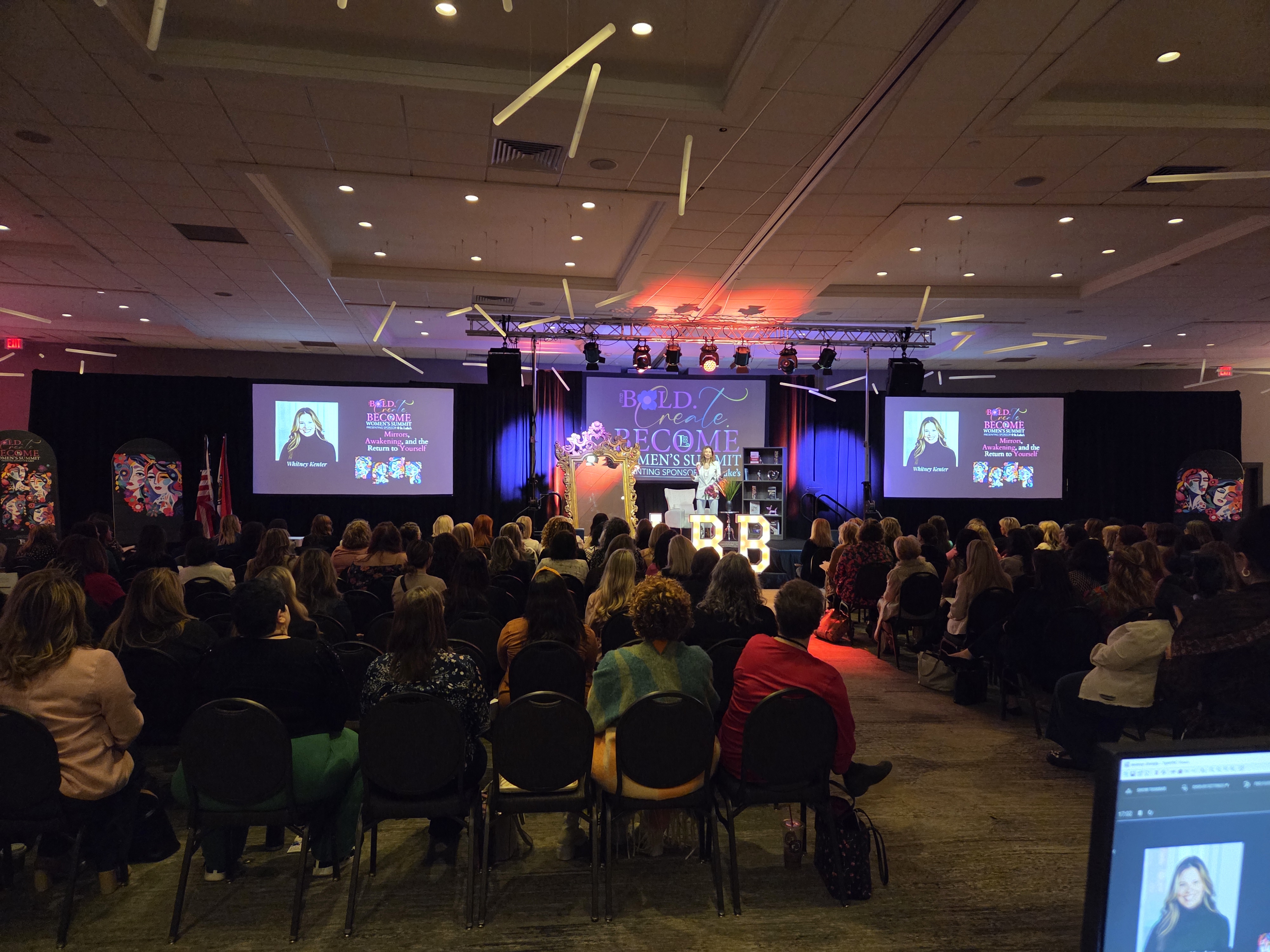 A full-house general session run by Essential AV — an engaged audience facing a lit main stage and projection screens.