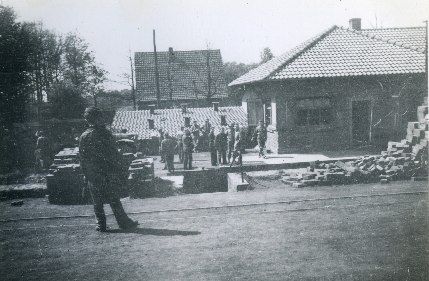 Soldiers Gathered at a Small Rail Depot with Stacked Building Material, Postwar Europe