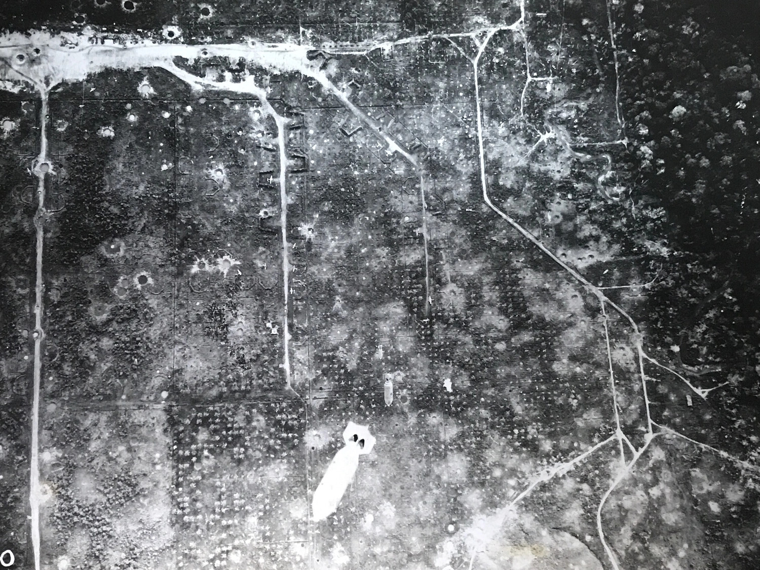 Aerial Photograph: String of 500-lb Bombs Falling on Plane Revetments, Wewak, New Guinea