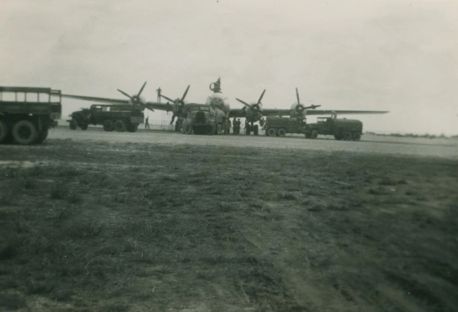 Four-Engine Heavy Bomber on Airfield Hardstand with Ground Support Vehicles, WWII Era