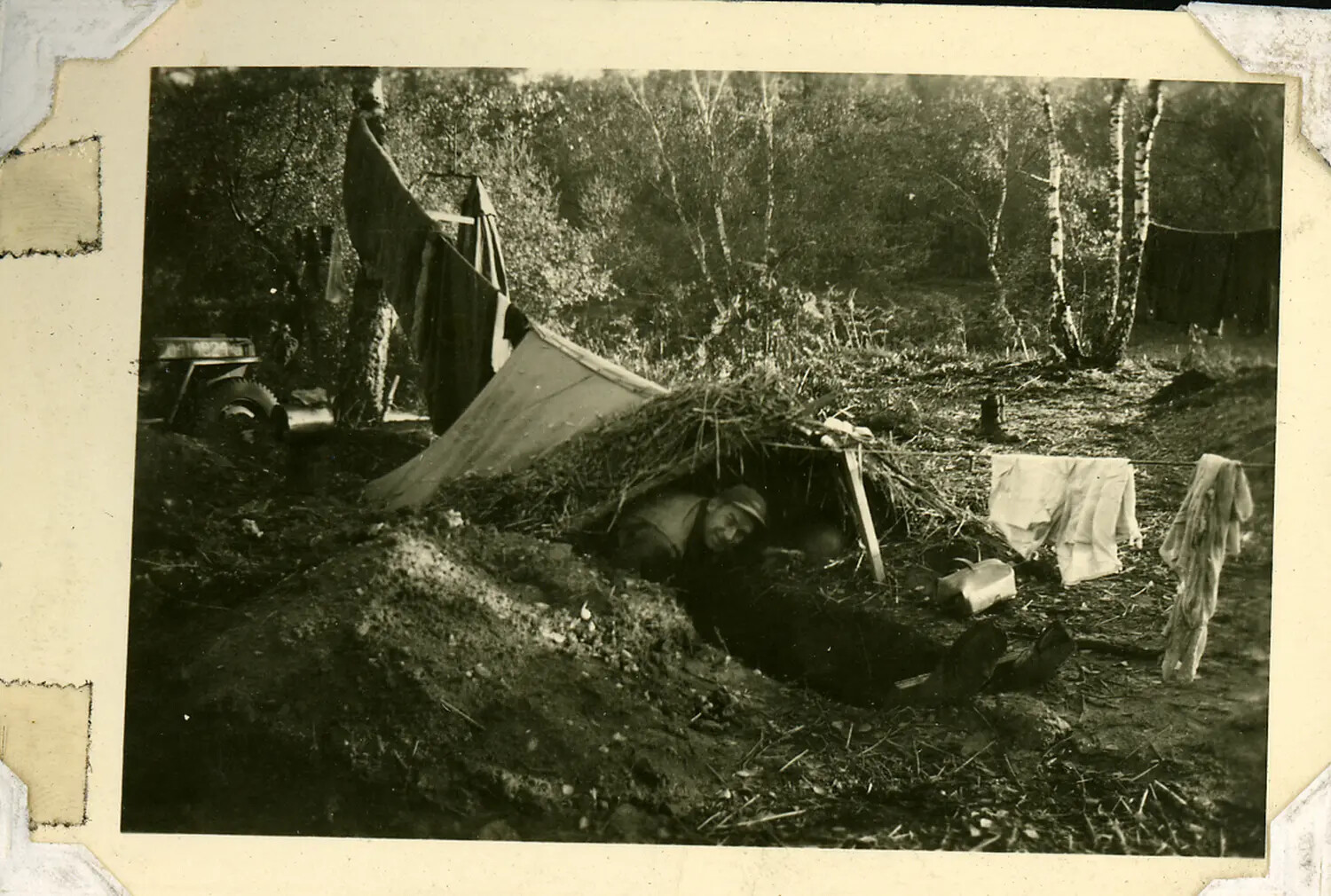 Soldier in Camouflaged Field Dugout Shelter, WWII Bivouac Album