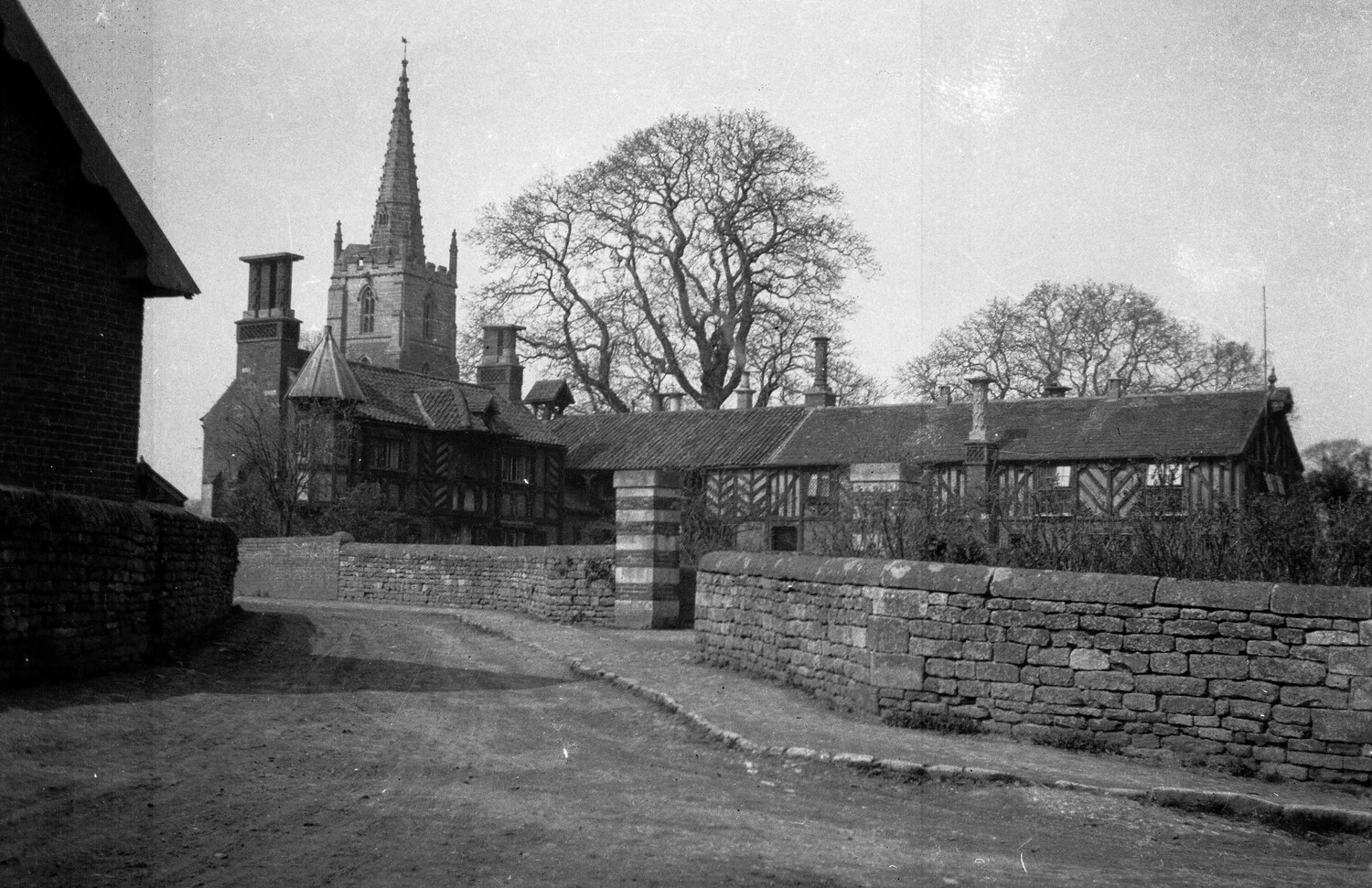English Village Scene with Tudor Church and Timber-Framed Almshouses, WWI Era
