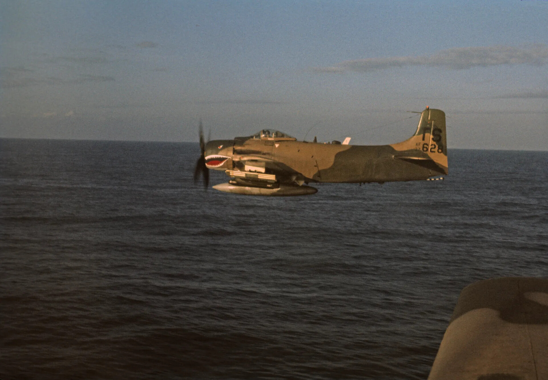 USAF A-1 Skyraider with Shark-Mouth Nose Art in Flight Over Water, Vietnam War Era